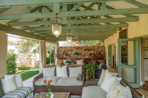 an outdoor patio with white couches and a wooden pergola at The Parkwood in Johannesburg