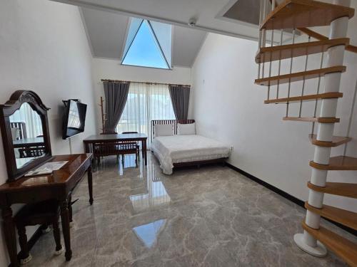 a living room with a staircase and a desk and a chair at Samcheok santiago pension in Samcheok
