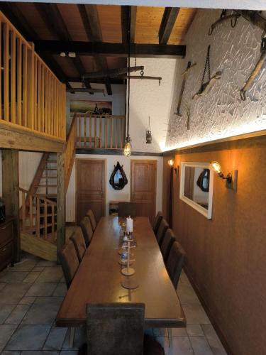 a dining room with a long wooden table and chairs at Gîte Oncle Yerry Ostheim in Ostheim