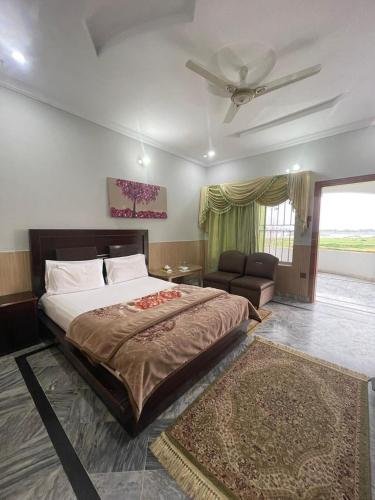 a bedroom with a large bed and a ceiling fan at lake view hotel and resort in Khānpur