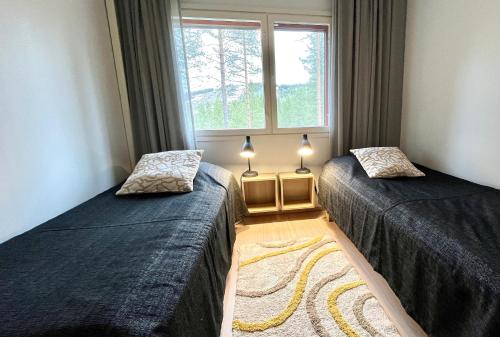 een slaapkamer met twee bedden en een raam bij Vuokatti Weekend Piste in Vuokatti