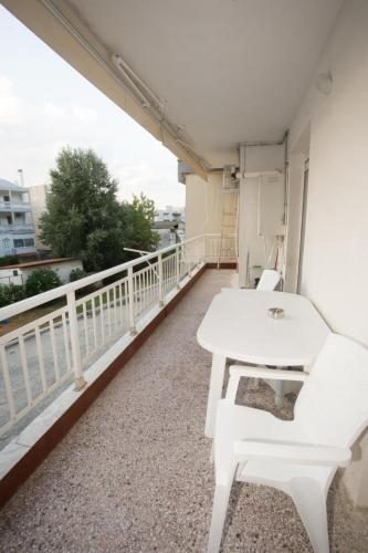 a balcony with a white table and chairs on it at Thessaloniki Blue Escape by ΜΡS in Perea