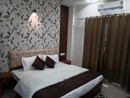 Schlafzimmer mit einem Bett mit einer schwarz-weißen Tapete in der Unterkunft Hotel springwood suites in Sohāna
