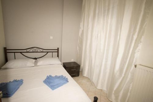 a bedroom with a bed with two blue gloves on it at Thessaloniki Blue Escape by ΜΡS in Perea