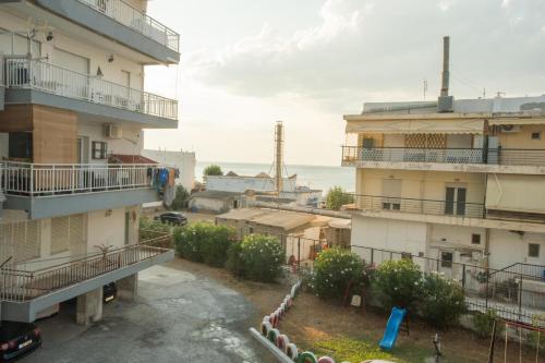an apartment building with a parking lot and the ocean at Thessaloniki Blue Escape by ΜΡS in Perea