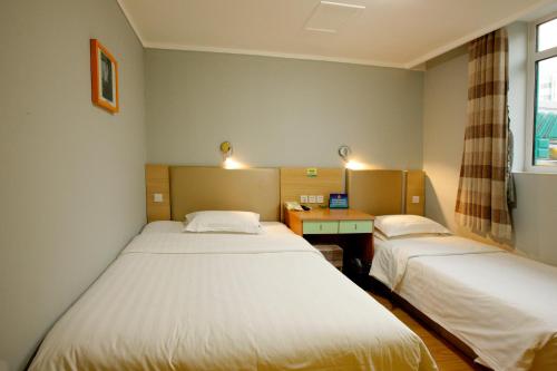 a room with two beds and a desk and a window at Zhong An Hotel Beijing Former Residence of Journalist Edgar Snow -Free laundry service,Free freshly ground coffee,Provide tourism and ticketing service ,English service ,Near Tian'AnMen Forbidden City,Wangfujing walking street in Beijing