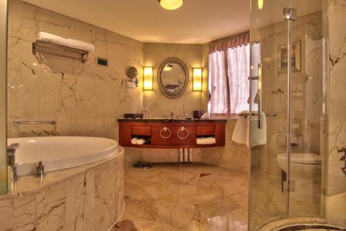 a bathroom with a tub and a sink and a mirror at Citic Ningbo International Hotel in Ningbo