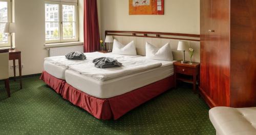 a hotel room with a bed with two pillows on it at SchlafGut AppartementHotel in Leipzig