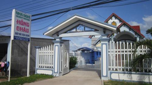 a white fence in front of a house with a sign at Hong Chau Guesthouse in Phu Quoc