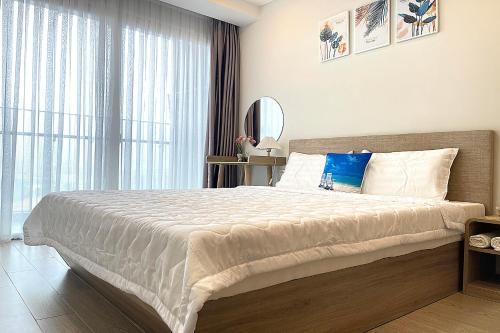 a bedroom with a large bed and a large window at The Sóng Luxury Apartment Vung Tau - Tuấn Hoà Homestay in Vung Tau