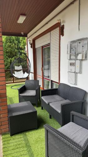 a patio with wicker furniture on a porch at Villa Negra 1 in Balatonfenyves