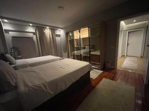 a bedroom with a large bed and a large mirror at المهندسين شقه سوبر لوكس - محى الدين ابو العز in Cairo