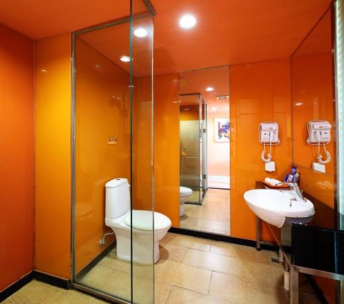 a bathroom with two sinks and a toilet and a shower at Yanjiang East Garden Inn in Guangzhou