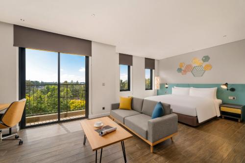 a hotel room with a bed and a couch at HIIVE by fusion Binh Duong New City - VSIP 2 in Thu Dau Mot