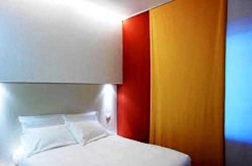 a bedroom with a white bed and a colorful wall at Il Bocciolo Della Rosa in SantʼAgostino