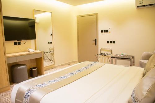 a hotel room with a large bed and a television at ﺳﹻﻠﹿﺲ ﻟﻠﺸﻘﻖ اﻟﻤﺨﺪومة - الروابي in Riyadh