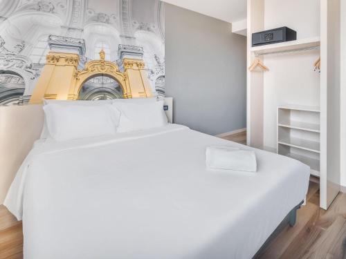 a bedroom with a white bed and a wall mural at B&B HOTEL Torino Orbassano in Turin