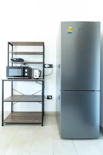 a refrigerator in a kitchen next to a shelf at Ale house experience in Riola Sardo