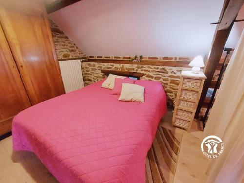 a bedroom with a bed with a pink blanket at La Herrière in Méral