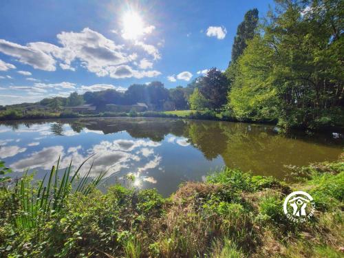 a river with the reflection of the sky in the water at La Herrière in Méral