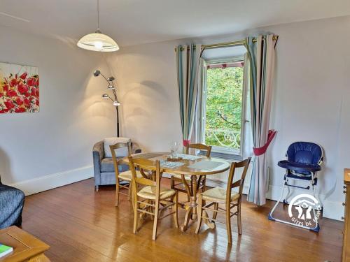 ein Esszimmer mit Tisch und Stühlen und einem Fenster in der Unterkunft NORMANDIE in Lassay