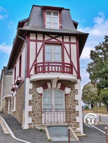 a red and white house with a balcony at NORMANDIE in Lassay