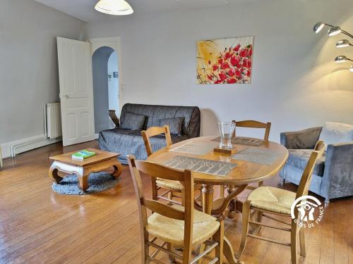 ein Wohnzimmer mit Tisch, Stühlen und Sofa in der Unterkunft NORMANDIE in Lassay