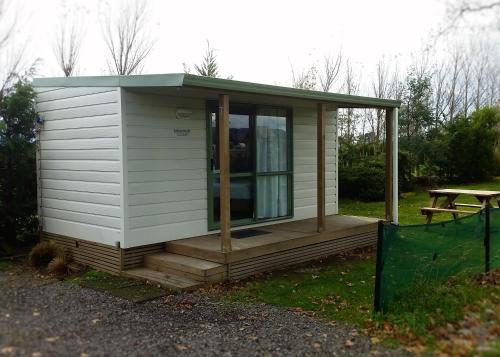 a tiny house with a porch and a picnic table at Martinborough TOP 10 Holiday Park in Martinborough 