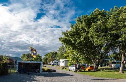 a parking lot with a tent and a tree at Martinborough TOP 10 Holiday Park in Martinborough 