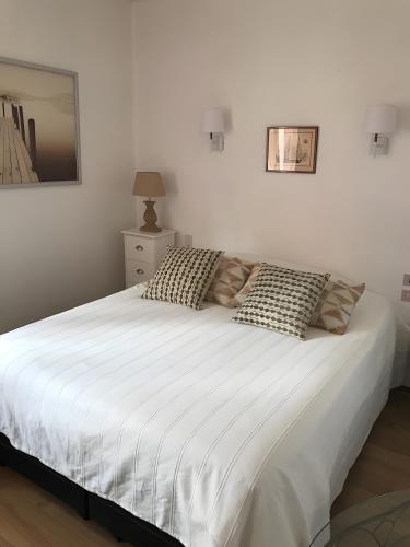 una camera da letto con un grande letto bianco con cuscini di Chambre D'hote Chez Amaya a Gujan-Mestras
