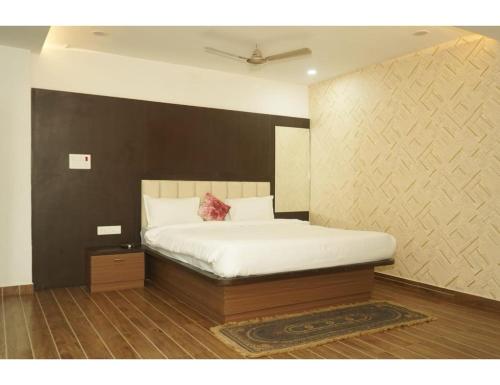 a bedroom with a white bed with a black wall at Hotel Dynasty, Deoghar, in Deoghar