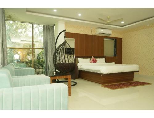 a bedroom with a hammock bed and a living room at Hotel Dynasty, Deoghar, in Deoghar