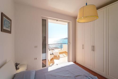 a bedroom with a bed and a view of the ocean at Sarande Barracuda View Apartment in Sarandë