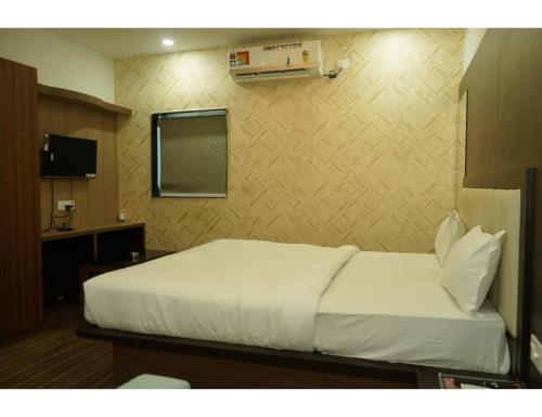 a bedroom with a white bed in a room at Hotel Dynasty, Deoghar, in Deoghar