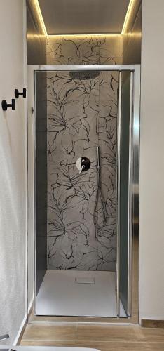 a bathroom with a glass door with a wall at Derosas House in Golfo Aranci