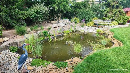a bird statue in a pond in a garden at Gîte Oncle Yerry Ostheim in Ostheim