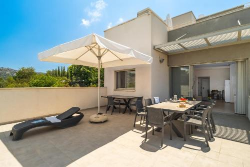 a patio with an umbrella and a table and chairs at Keshet Eilon Galilee Views Retreat by Sea N' Rent in Elon