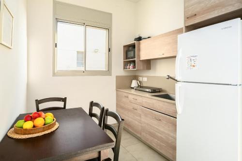 a kitchen with a table with a bowl of fruit on it at Keshet Eilon Galilee Views Retreat by Sea N' Rent in Elon