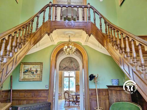 an ornate staircase in a home with green walls at Château de la Roche, 11-12 personnes in Ahuillé
