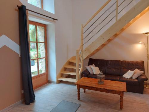 a living room with a couch and a wooden table at La Petite Maison in Vaiges