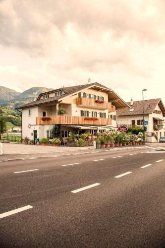 a large building on the side of a street at B&B Pizzeria Zur Traube in Montagna