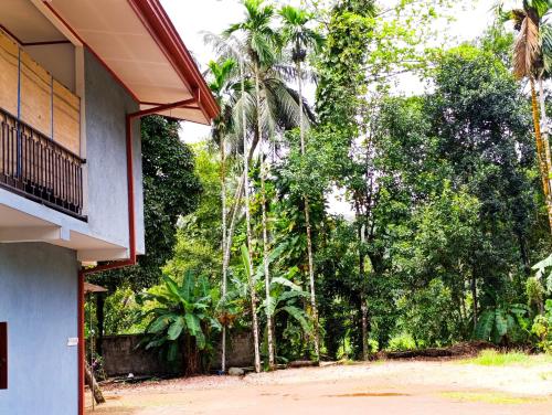 a porch of a house with palm trees at LAKROinn in Matugama