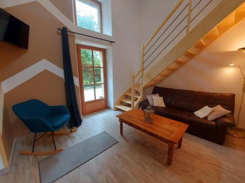 a living room with a couch and a table at La Petite Maison in Vaiges