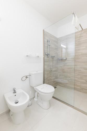 a bathroom with a toilet and a shower and a sink at Hotel Maroli Mikulov in Mikulov