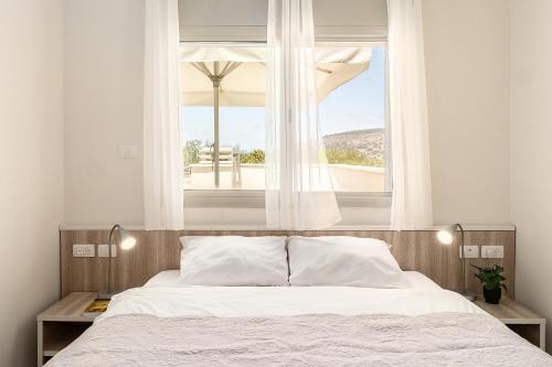 a bedroom with a large bed with a window at Keshet Eilon Galilee Views Retreat by Sea N' Rent in Elon