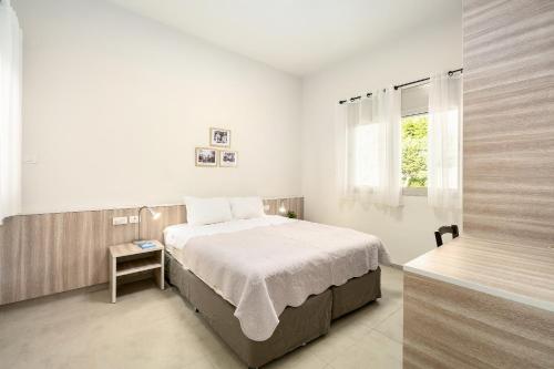 a white bedroom with a bed and a window at Keshet Eilon Galilee Views Retreat by Sea N' Rent in Elon