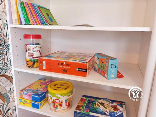 a book shelf with toys and boxes on it at Un instant à Saulges, jusqu'à 12 personnes in Saulges