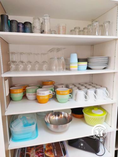 a shelf full of dishes and bowls and plates at Un instant à Saulges, jusqu'à 12 personnes in Saulges