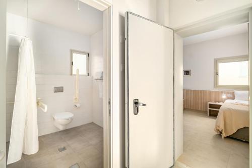 a white bathroom with a toilet and a bed at Keshet Eilon Galilee Views Retreat by Sea N' Rent in Elon