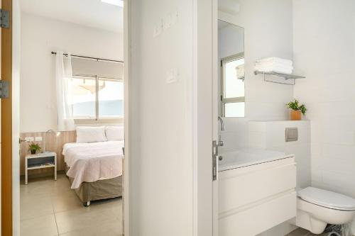 a white bathroom with a bed and a toilet at Keshet Eilon Galilee Views Retreat by Sea N' Rent in Elon